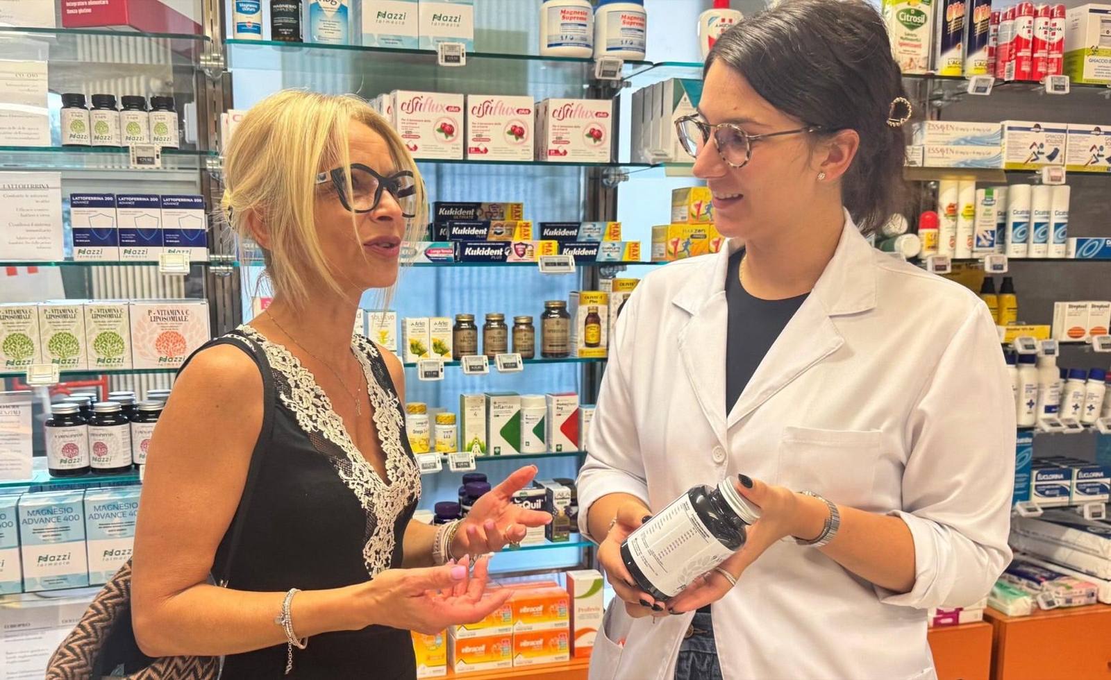 Una farmacista della Farmacia Nazzi consiglia un integratore a una cliente, al banco